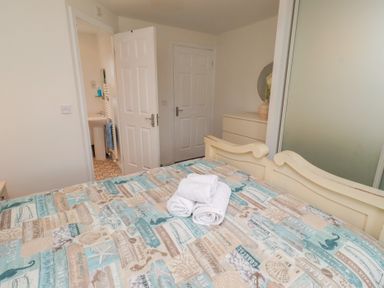 A bedroom with a bed and towels on it at Sugar Sands in Longhoughton