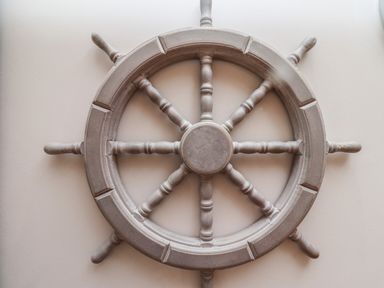 A ship steering wheel mounted on a wall at The Boathouse (Seahouses) in Seahouses