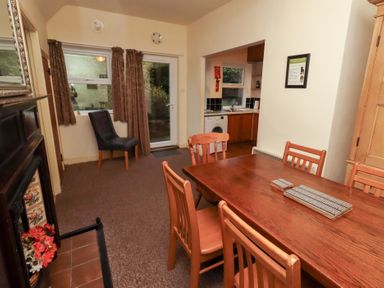 A dining room with table and chairs at Wayside Cottage in Newton-by-the-Sea