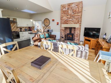 A living room with a fireplace and kitchen in Red Fox, Lucker