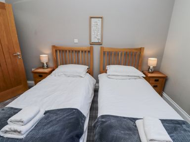 A bedroom with two single beds and nightstands at Red Fox in Lucker
