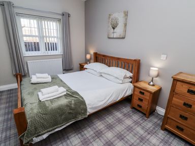 A bedroom with a wooden bed and nightstands at Red Fox in Lucker