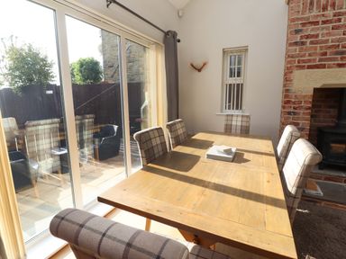 A dining room with a wooden table and chairs at Roe Deer in Lucker