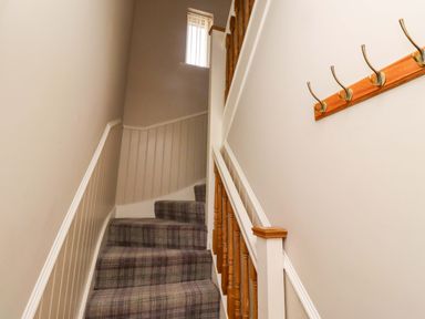 A staircase with a banister and hooks at Roe Deer in Lucker