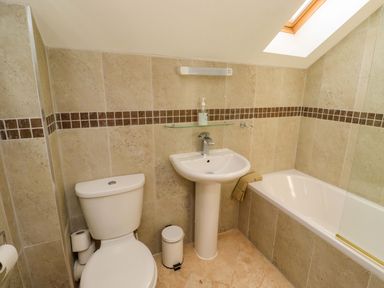 A bathroom with a toilet, sink, and bathtub at Roe Deer in Lucker