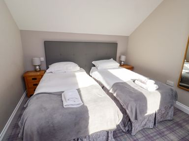 A bedroom with two beds and bedside tables at Roe Deer in Lucker