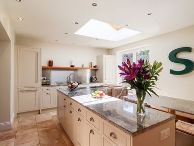 A kitchen with an island counter with flowers and fruit at No6 Sea Lane in Embleton
