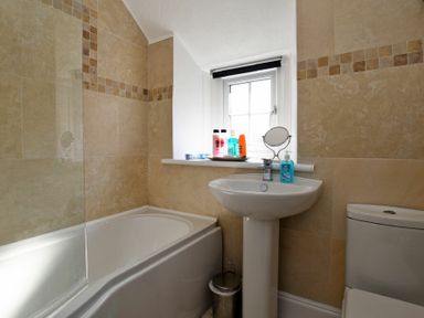 A bathroom with a bathtub sink toilet and small window at Turnstone Cottage Nr Bamburgh
