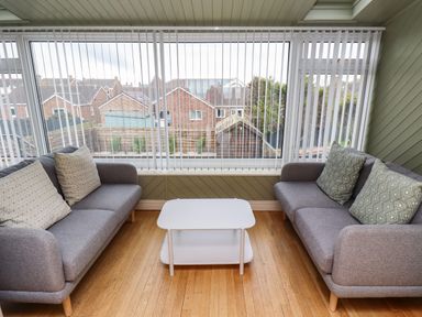 A room with two grey sofas facing each other and a white coffee table in the middle at Barnacle Cove in Beadnell