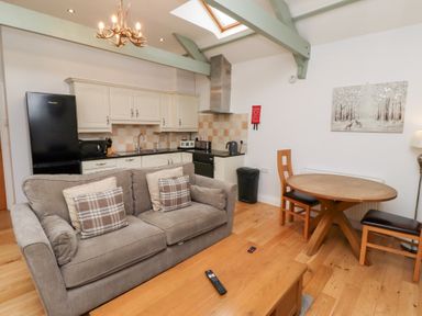A living room with a sofa and dining area at Chiff Chaff in Lucker