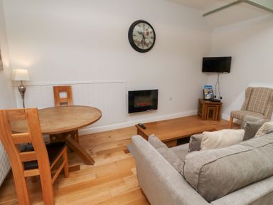 A living room with a table and sofa at Chiff Chaff in Lucker