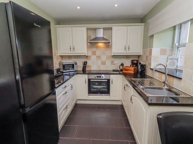 A kitchen with appliances and cabinets at Greenfinch in Lucker