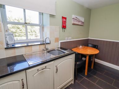 A kitchen with a sink and table at Greenfinch in Lucker