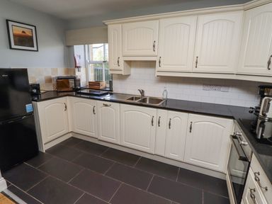 A kitchen with sink and appliances at Rosefinch in Lucker