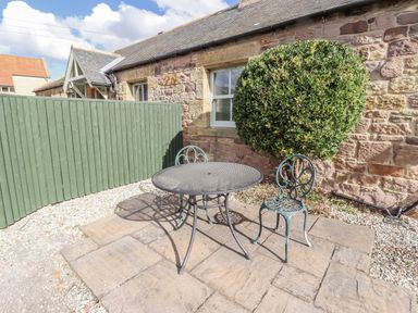 An outdoor area with a table and chairs at Rosefinch in Lucker