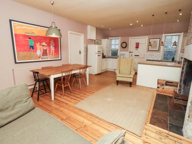 A kitchen with a dining table and chairs at Armstrong Cottages No6 Bamburgh