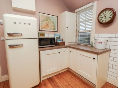 A kitchen with a fridge and microwave at Armstrong Cottages No6 in Bamburgh
