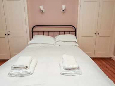 A bedroom with a bed and towels at Armstrong Cottages No6 in Bamburgh