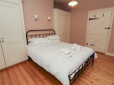 A bedroom with a bed and towels at Armstrong Cottages No6 in Bamburgh