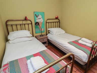 A bedroom with two single beds and a nightstand at Armstrong Cottages No6 in Bamburgh