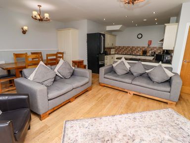 A living room with sofas and a dining table at Pipistrelle in Bamburgh