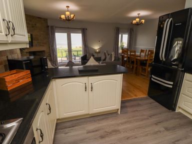 A kitchen with a refrigerator and dining area at Pipistrelle in Bamburgh