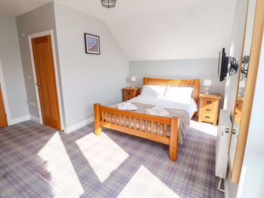 A bedroom with a bed and bedside tables at Pipistrelle in Bamburgh