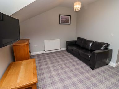 A living room with a sofa and television at Pipistrelle in Bamburgh