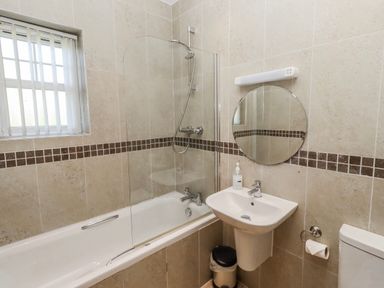 A bathroom with a bathtub and shower at Goosander in Bamburgh
