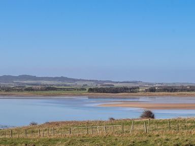 A landscape with a river and fields at Goosander in Bamburgh