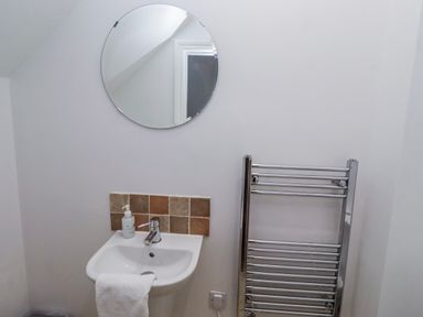 A washbasin and mirror in a bathroom at Jackdaw in Bamburgh