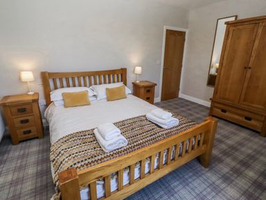 A bedroom with a bed and furniture at Jackdaw in Bamburgh