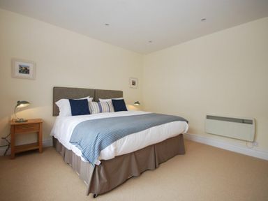 A bedroom with a bed pillows side tables and lamps at Coastal Haven in Seahouses