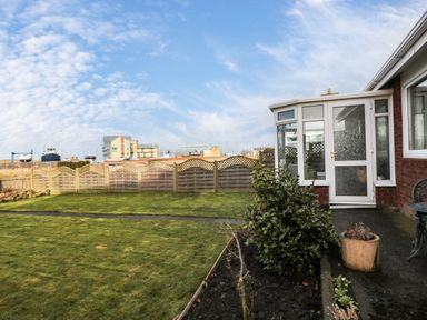 A backyard garden with lawn plants and a conservatory at Arcadie in Amble