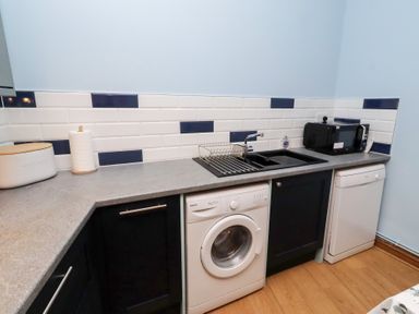 A kitchen with a washing machine and dishwasher at Riverside Cottage in Warkworth