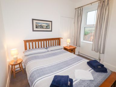 A bedroom with a bed and bedside table at Riverside Cottage in Warkworth