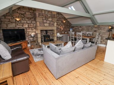 A living room with a sofa and television at Old Mill (Lucker) Lucker