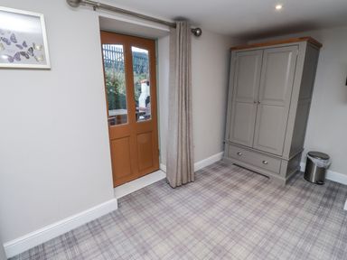 A room with a wardrobe and door at Old Mill (Lucker) Lucker