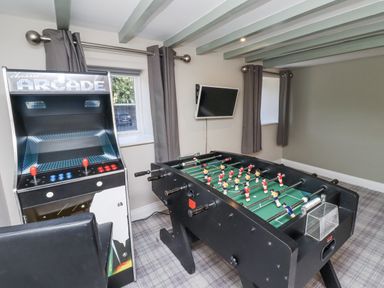 A game room with an arcade machine and a foosball table at Old Mill (Lucker)