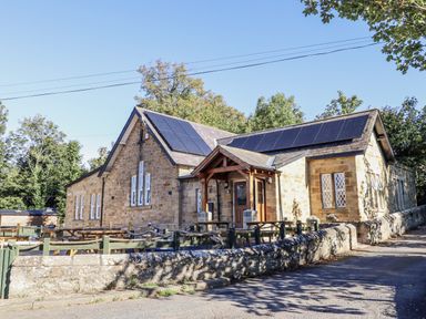 A building with solar panels and seating area at Old Mill (Lucker) Lucker