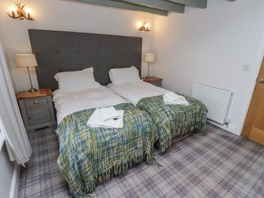 A bedroom with two beds and nightstand at Millstone in Lucker