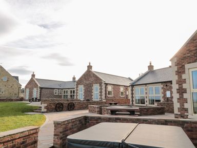An outdoor area with brick buildings and paved walkways at Bothy Cottage in Embleton