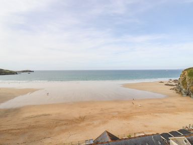 A sandy beach with a few people near water and cliffs at 33 Cliff Edge in Newquay
