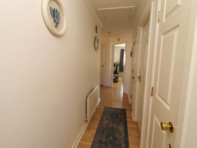 A hallway with doors and a radiator at 6 Westview in Embleton