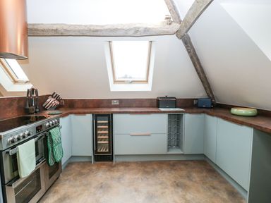 A kitchen with stove oven wine fridge and skylights at Palace Farmhouse in St Weonards