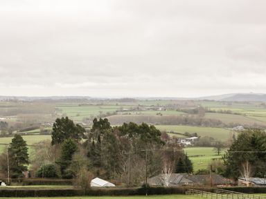 A rural landscape with fields trees fences and houses at Palace Farmhouse in St Weonards