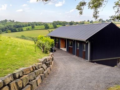 A house with a driveway and grass at Bwncath in Garthmyl