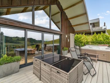 An outdoor area with hot tub and furniture at Bwncath in Garthmyl