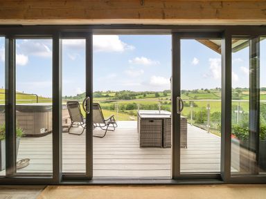 A balcony with outdoor furniture and a hot tub at Bwncath in Garthmyl
