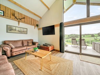A living room with a sofa and coffee table at Bwncath in Garthmyl